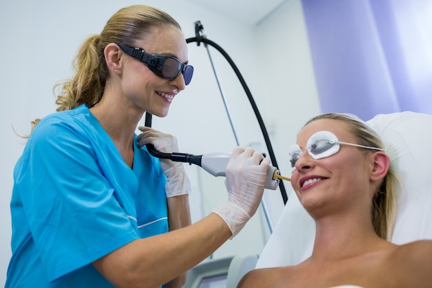 Vrouw die laserepilatiebehandeling op haar gezicht ontvangt