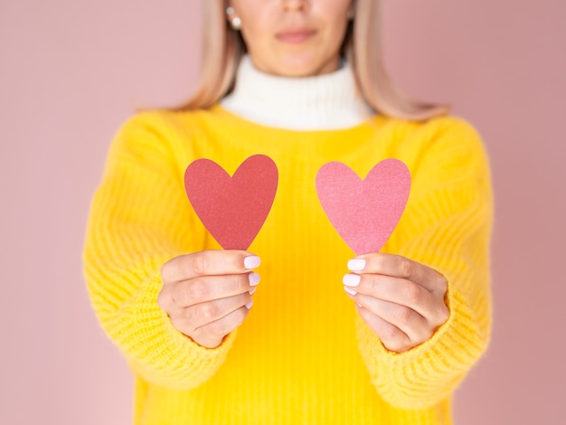 Gratis foto vrouw die leuke document harten houdt