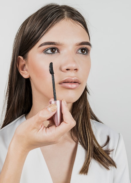 Vrouw die mascara op jong model toepast