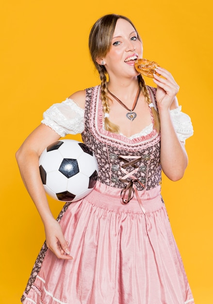 Vrouw die met bal een pretzel eet