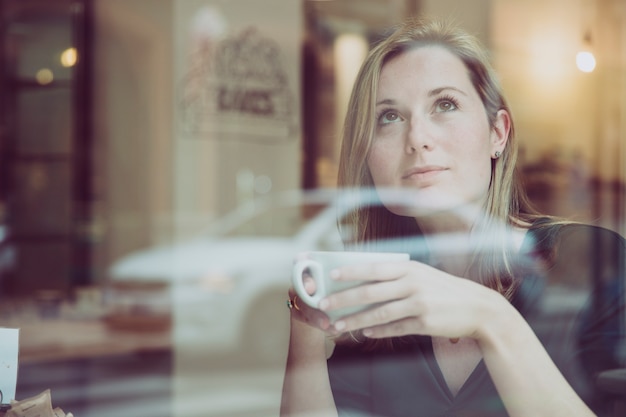 Gratis foto vrouw die met besnoeiing van hete drank omhoog kijkt