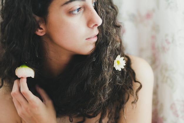 Vrouw die met bloemen in haar weg kijkt