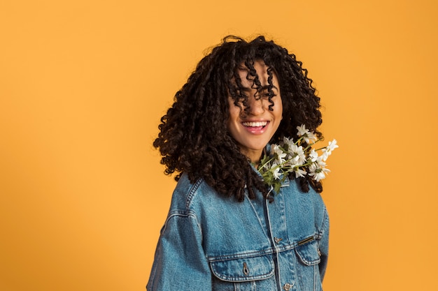 Vrouw die met bloemen onder jasje camera bekijkt