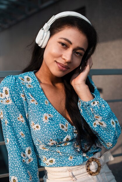 Vrouw die met bloemenoverhemd aan muziek luistert