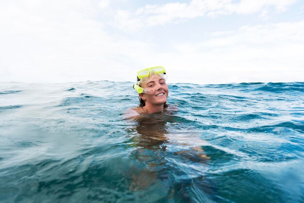 Vrouw die met duikuitrusting in de oceaan zwemt