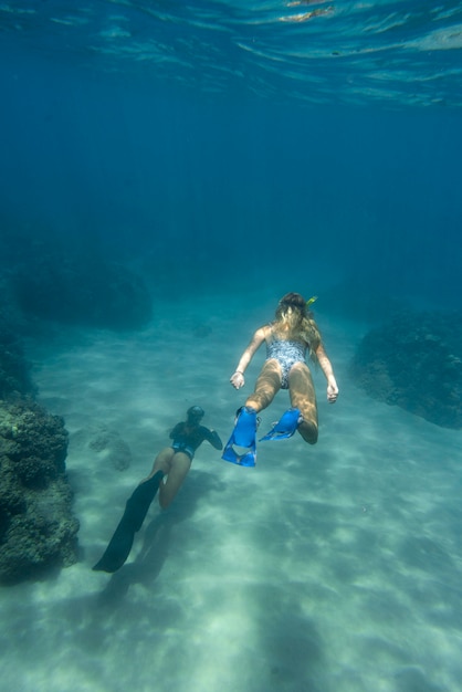 Vrouw die met duikuitrusting in de oceaan zwemt