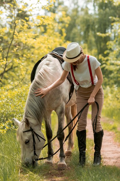 Vrouw die met een paard in het platteland loopt