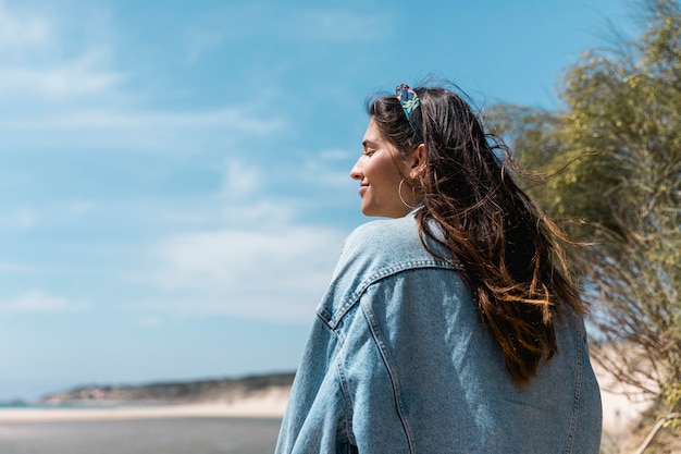 Vrouw die met gesloten ogen dichtbij tropisch strand zit