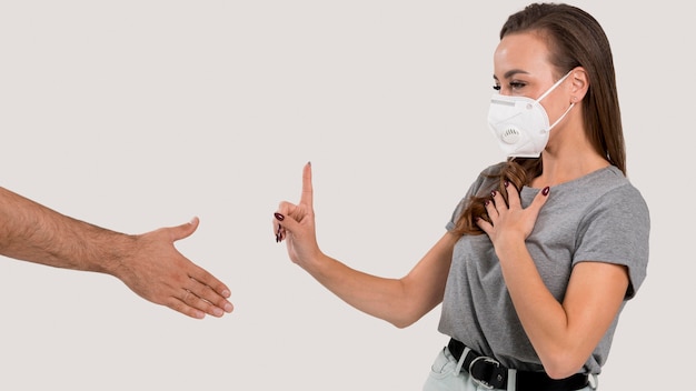 Vrouw die met gezichtsmasker handschud weigert