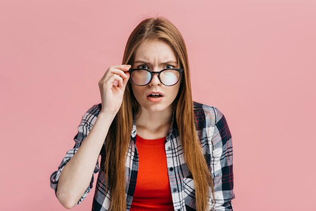 Vrouw die met glazen verdacht kijkt