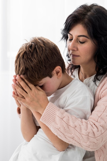 Gratis foto vrouw die met haar kind bidt