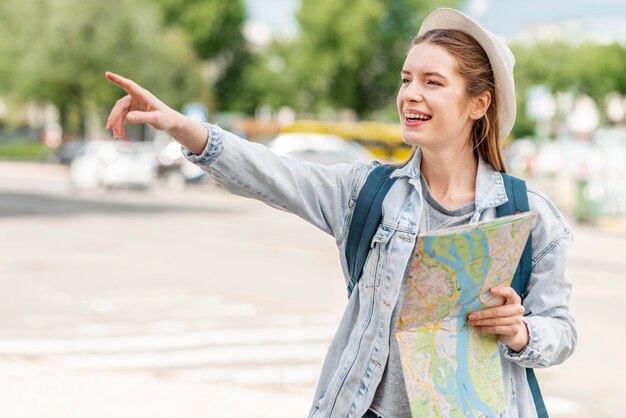 Vrouw die met kaart haar vinger in het lucht vooraanzicht richt