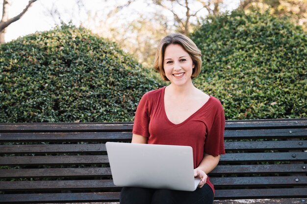 Vrouw die met laptop camera bekijkt