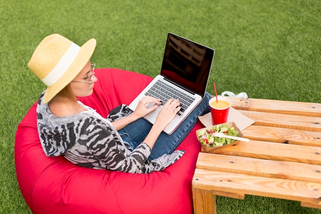 Gratis foto vrouw die met laptop salade bekijkt