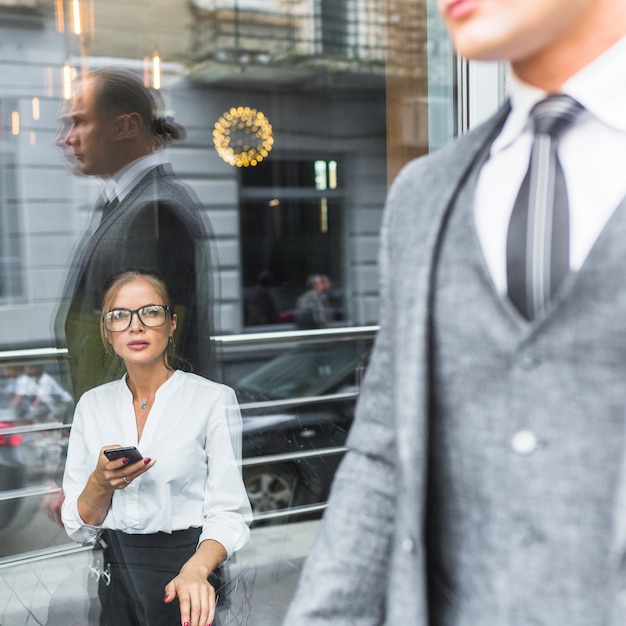 Gratis foto vrouw die met smartphone zakenman bekijkt