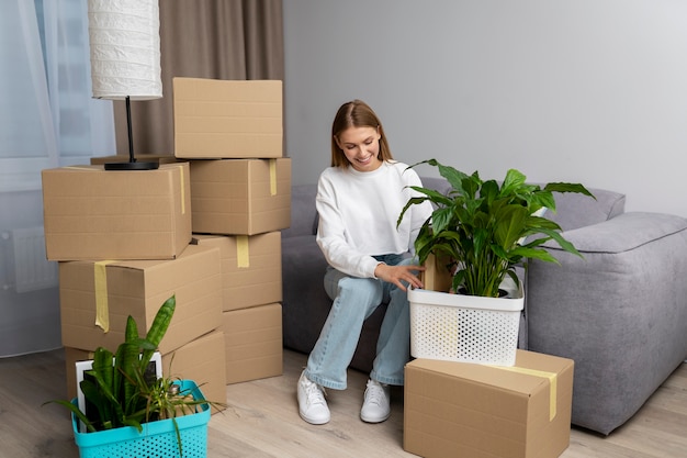 Vrouw die met spullen omgaat na verhuizing naar een nieuw huis