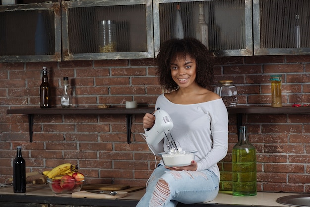 Vrouw die mixer in keuken met behulp van