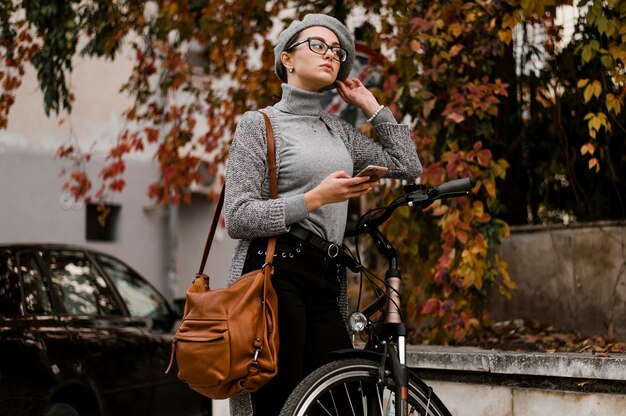 Vrouw die naast haar fiets loopt