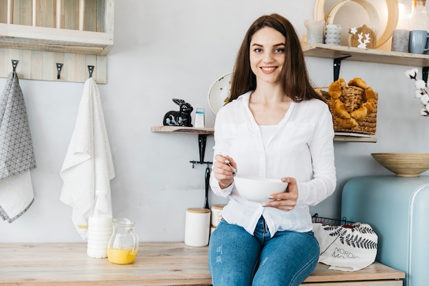 Vrouw die ontbijt heeft bij de keuken