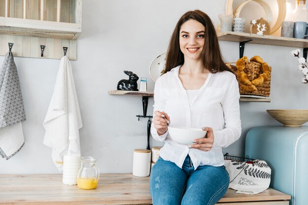 Vrouw die ontbijt heeft bij de keuken