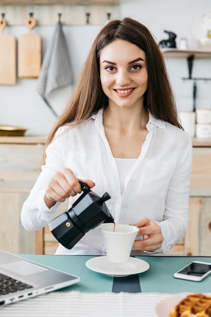 Vrouw die ontbijt heeft bij de keuken