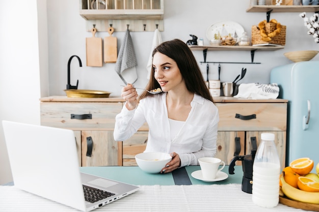 Vrouw die ontbijt heeft bij de keuken