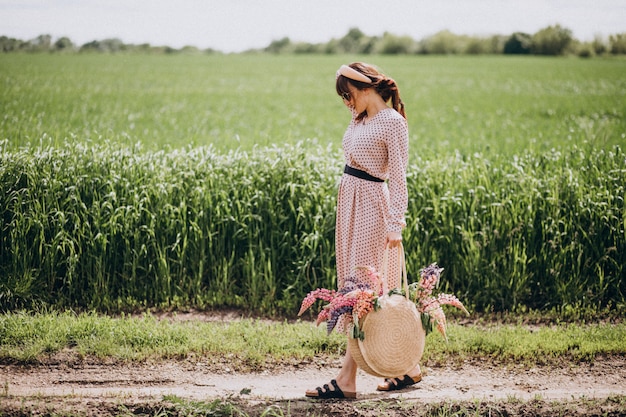 Vrouw die op een gebied met lupinuses loopt