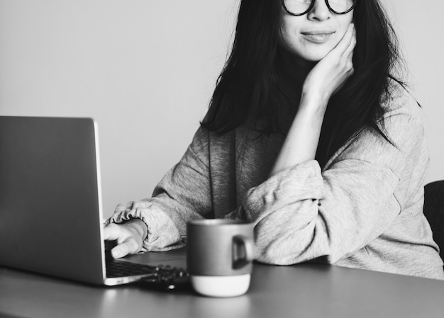 Vrouw die op een laptop in haar huis werkt