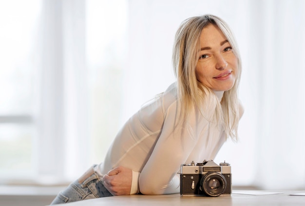 Vrouw die op een lijst naast een camerafoto leunt