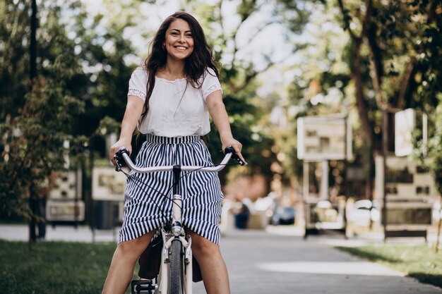 Vrouw die op fiets in de stad reist