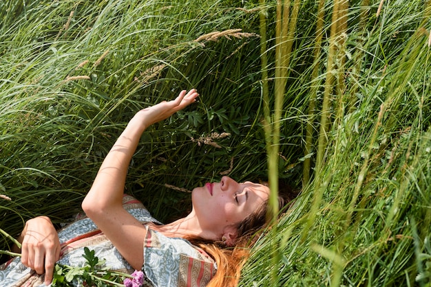 Vrouw die op gras hoge hoek legt