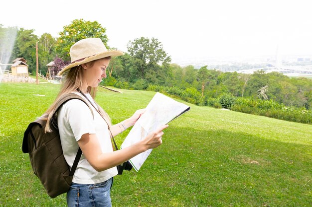 Vrouw die op gras op een kaart kijkt