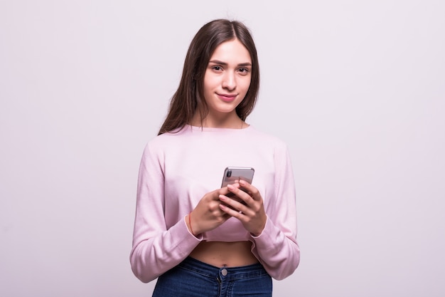 Vrouw die op haar mobiele telefoon texting die over een witte achtergrond wordt geïsoleerd