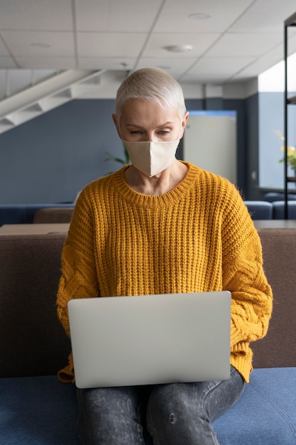 Vrouw die op het werk een medisch masker draagt