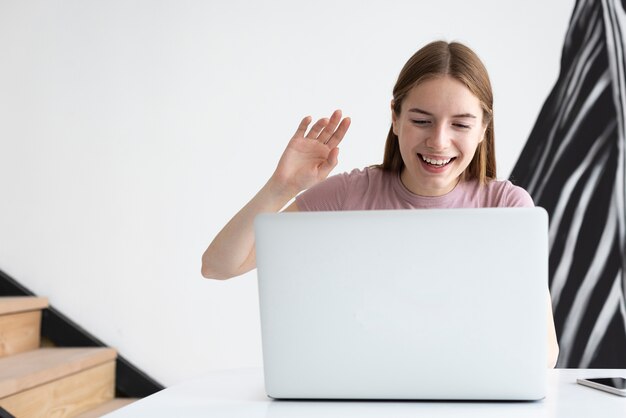 Vrouw die op iets dolkomisch op haar laptop let