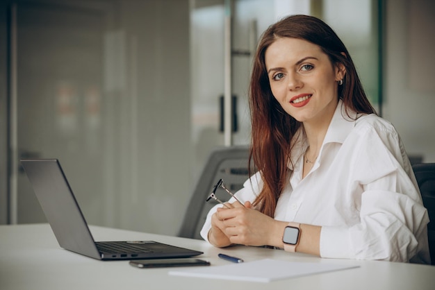 Vrouw die op kantoor op een computer werkt