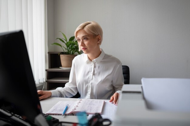Vrouw die op kantoor werkt en printer gebruikt