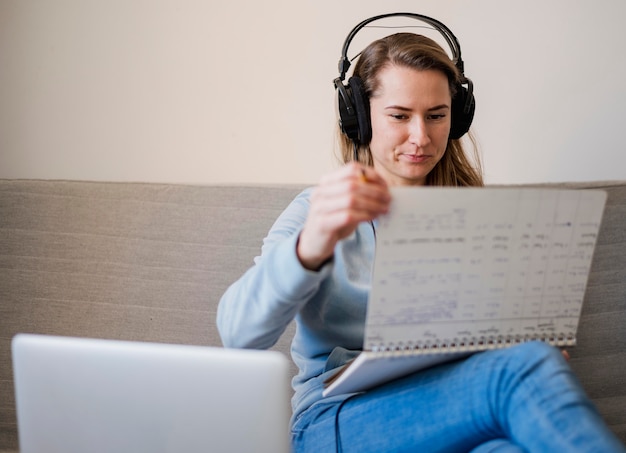 Gratis foto vrouw die op laag nota's van online klasse neemt