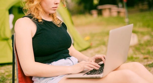 Vrouw die op laptop in openlucht typt