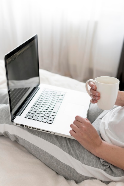 Vrouw die op laptop werkt en koffie drinken