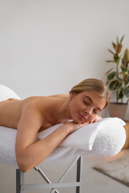 Vrouw die op massagebed ligt klaar voor sessie