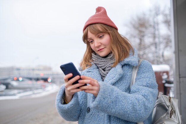 Vrouw die op straat wacht met smartphone