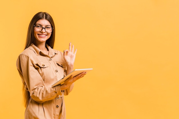 Gratis foto vrouw die op tablet in studio kijkt