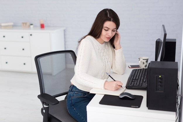 Gratis foto vrouw die op telefoon en het schrijven spreekt