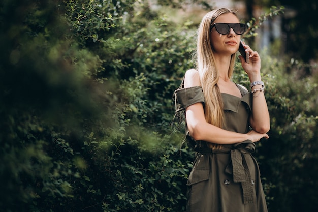 Gratis foto vrouw die op telefoon in park spreekt