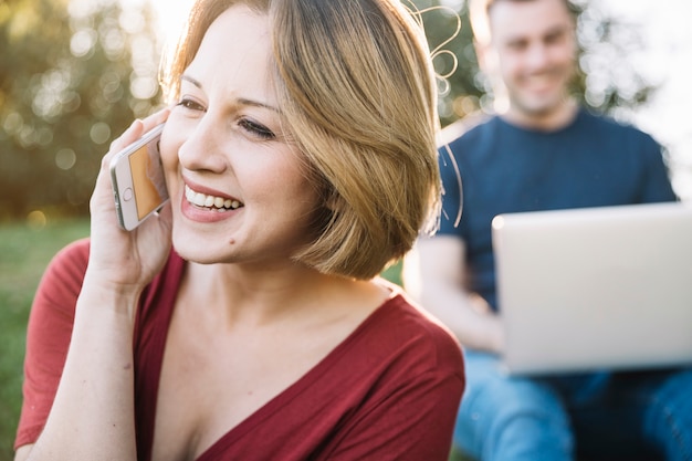 Vrouw die op telefoon spreekt dichtbij de vage mens