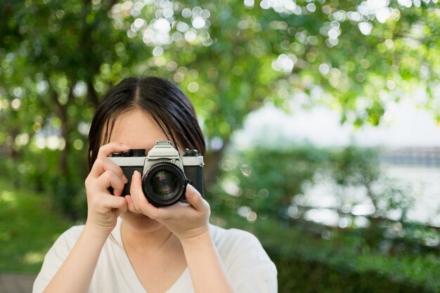 Vrouw die oude vintage camera gebruikt