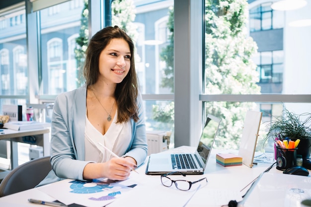 Vrouw die papierwerk doet en wegkijkt