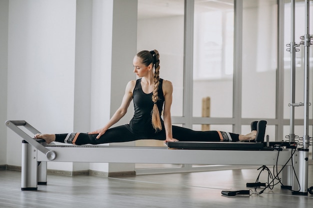 Vrouw die pilates in een pilateshervormer praktizeren