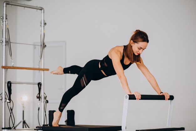 Vrouw die pilates op een hervormer doet